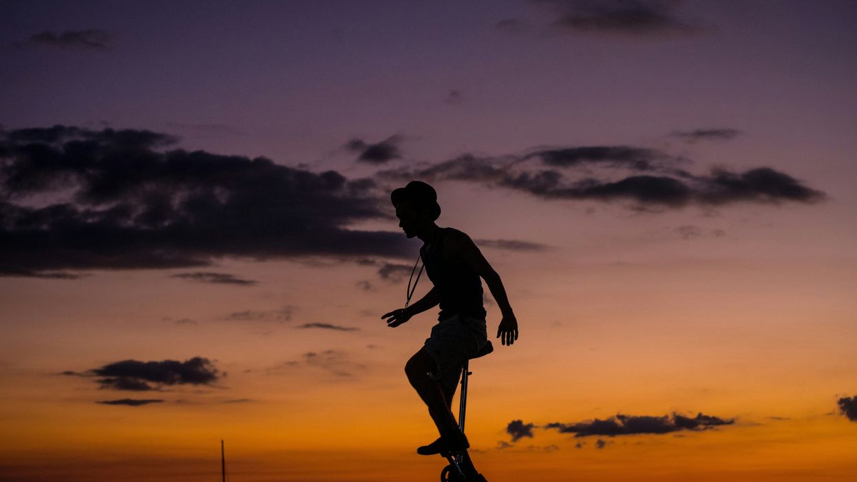 silhouette photo of man riding unicycle