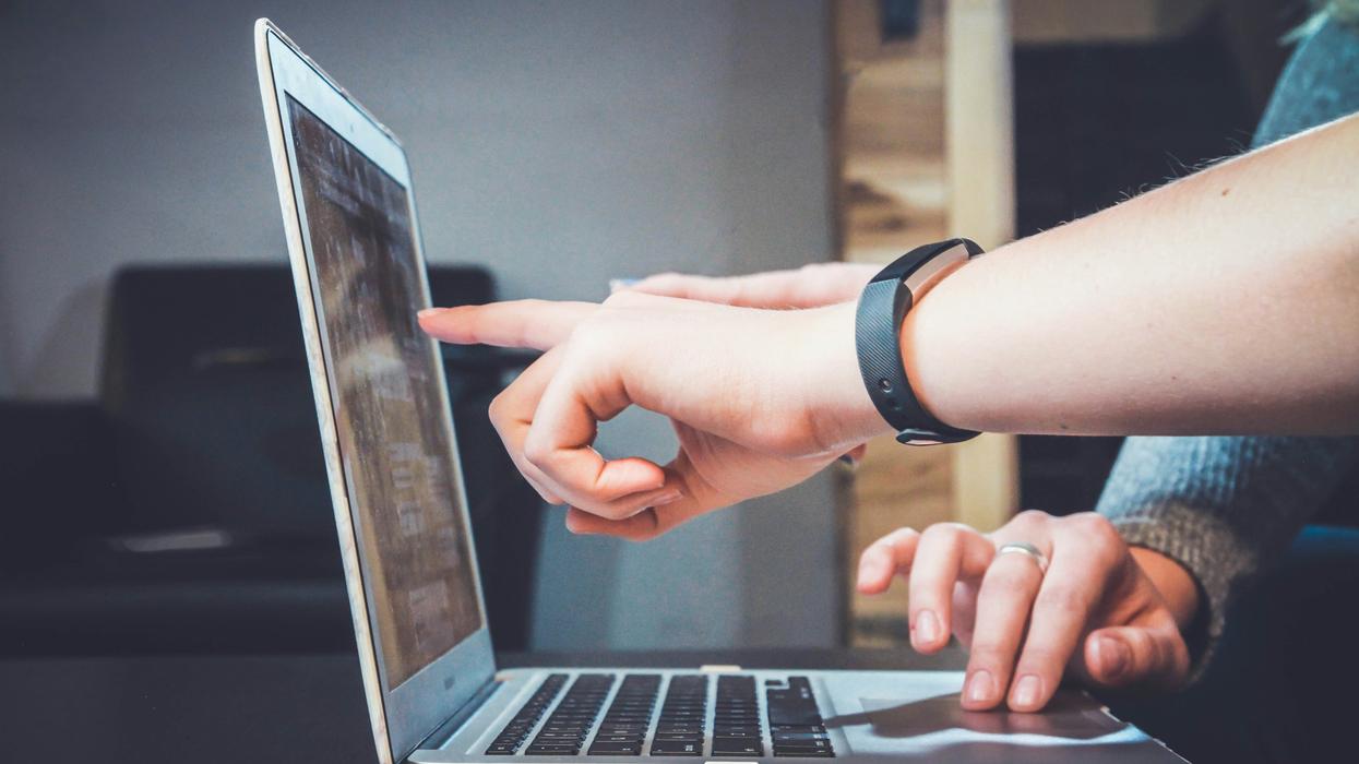 Someone pointing at a computer screen