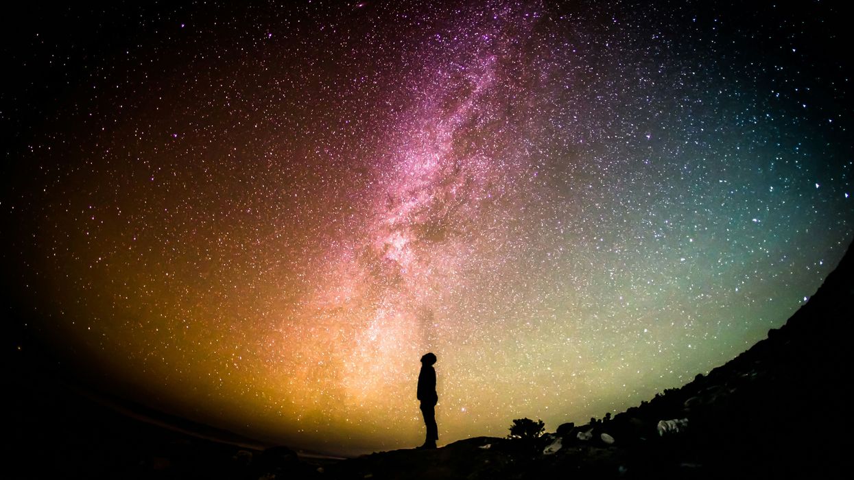 The sihouette of a man in front of a starlit sky