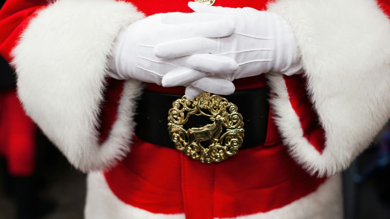 The waist of a man in a Santa Claus costume.