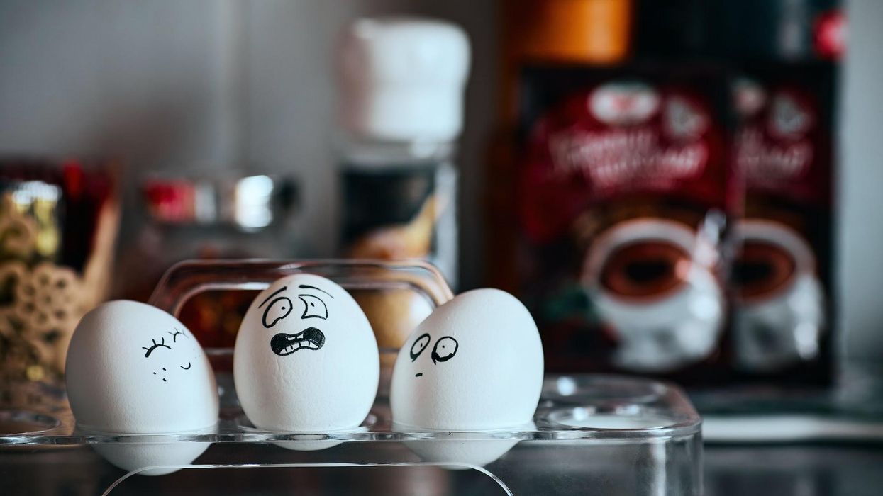 Three eggs with drawn faces face one another, one smiles, one is scared, the other slightly shocked