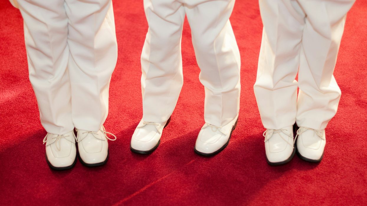 three sets of feet on a red carpet