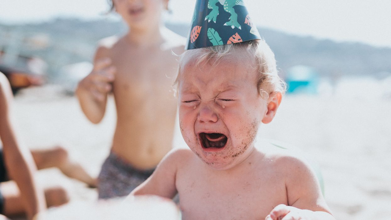 Toddler crying at beach birthday party