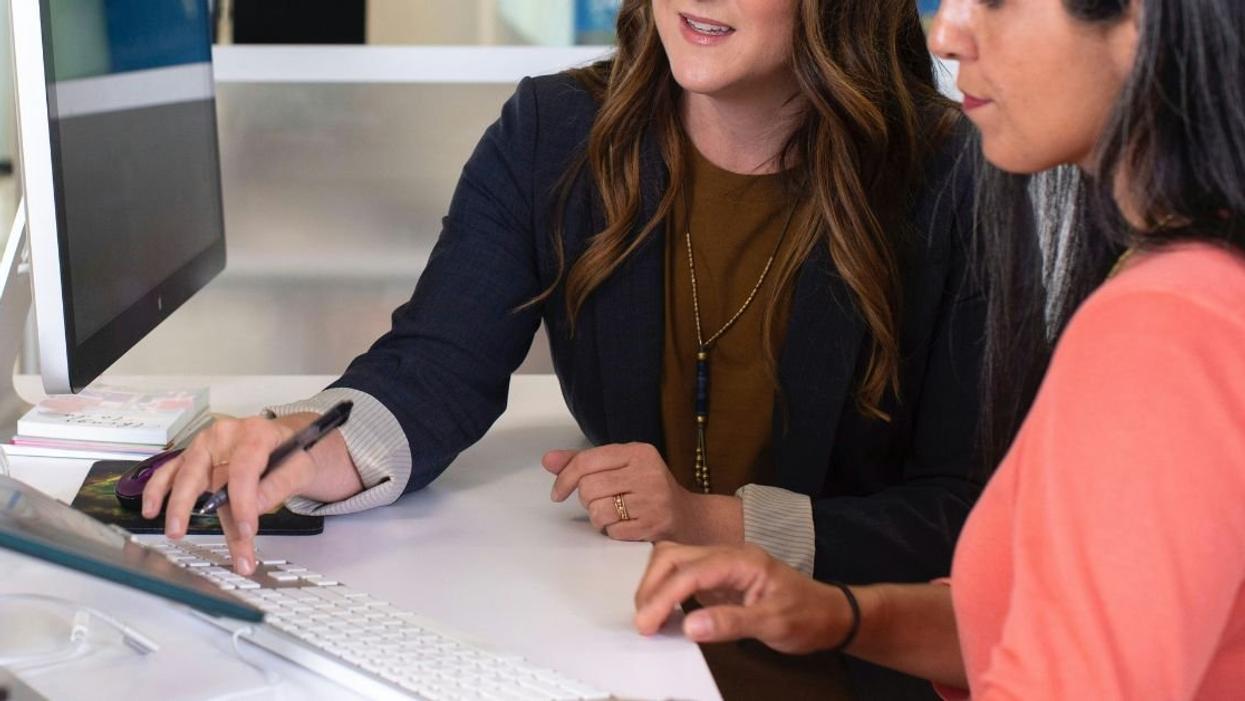 Two female coworkers working closely together