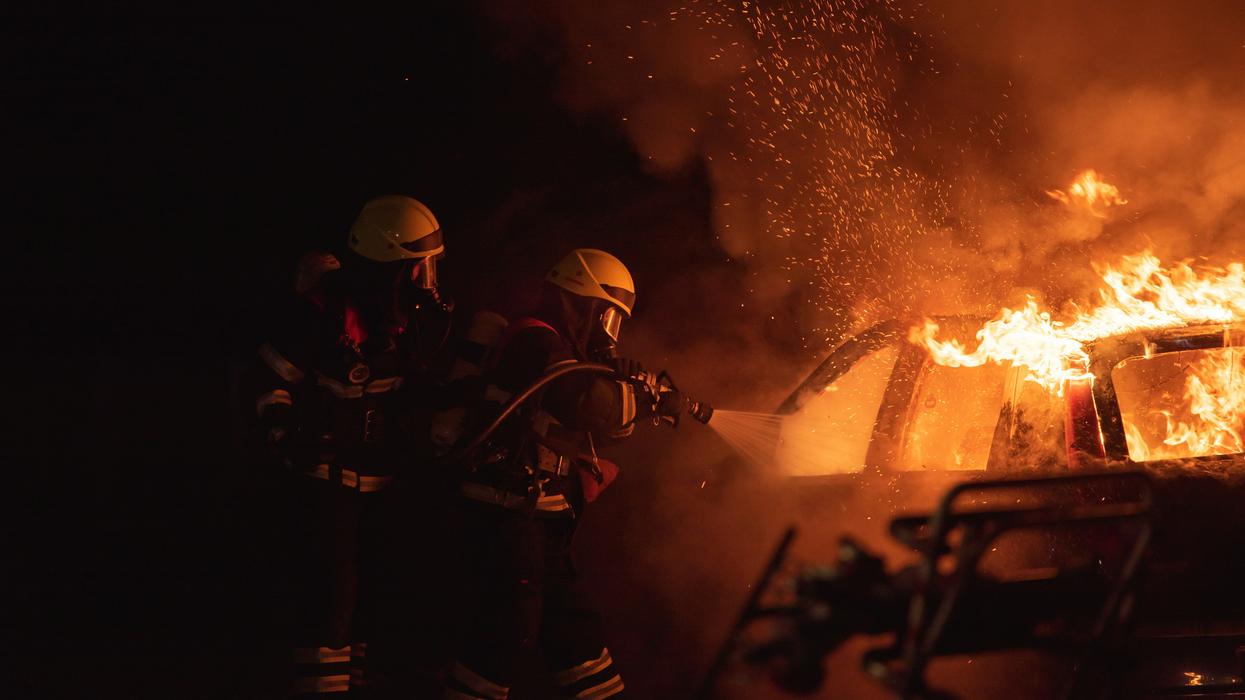 Two firefighters fighting a car fire
