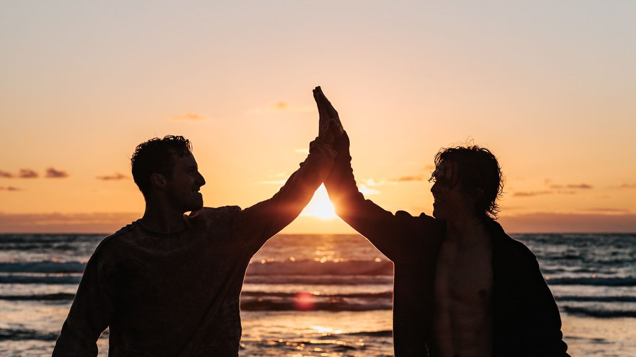 Two guys hi-fiving each other