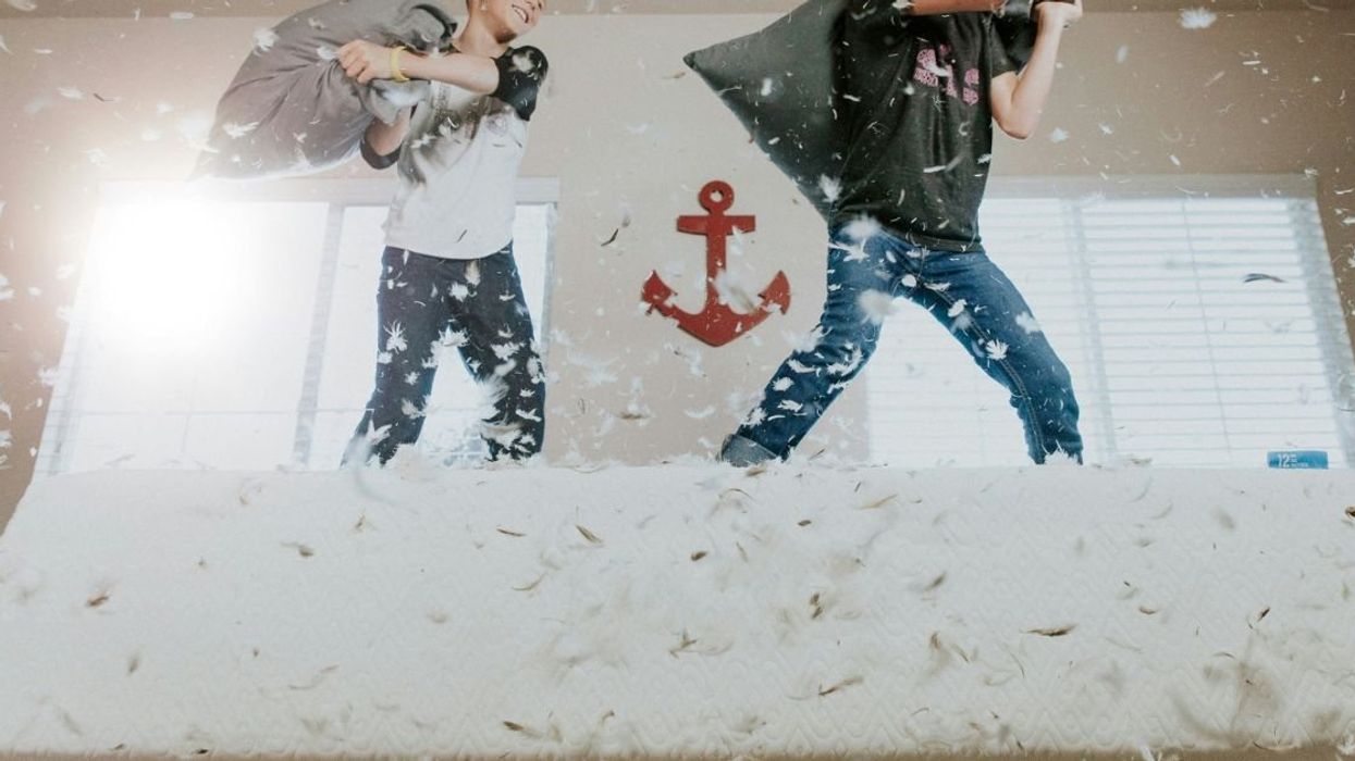 Two kids playing pillow fight