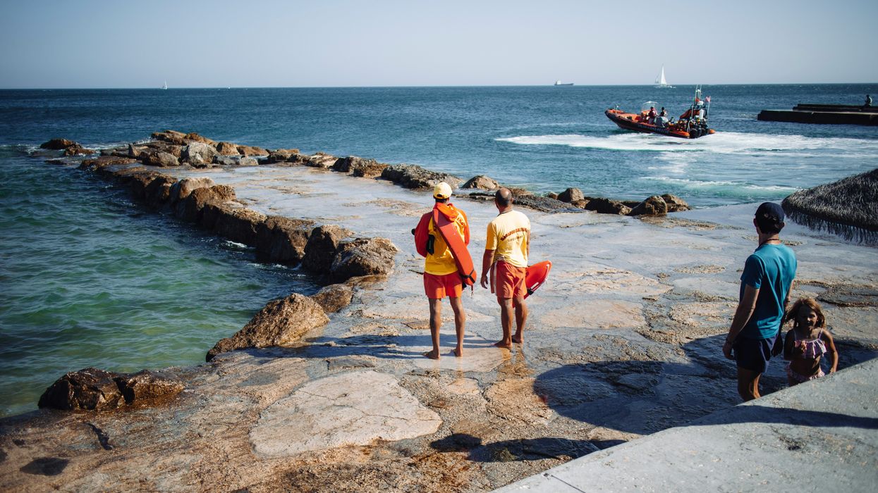 Two life guards standing on a rock deck.
