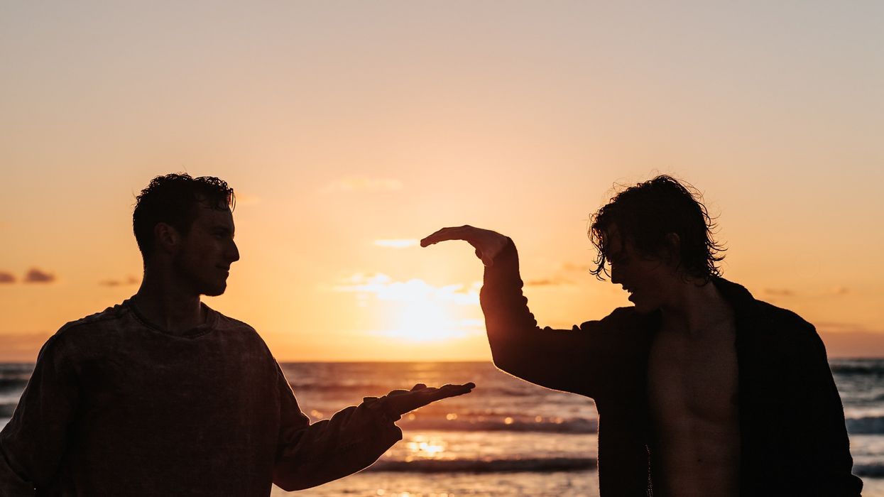 Two men on the beach giving each other high five