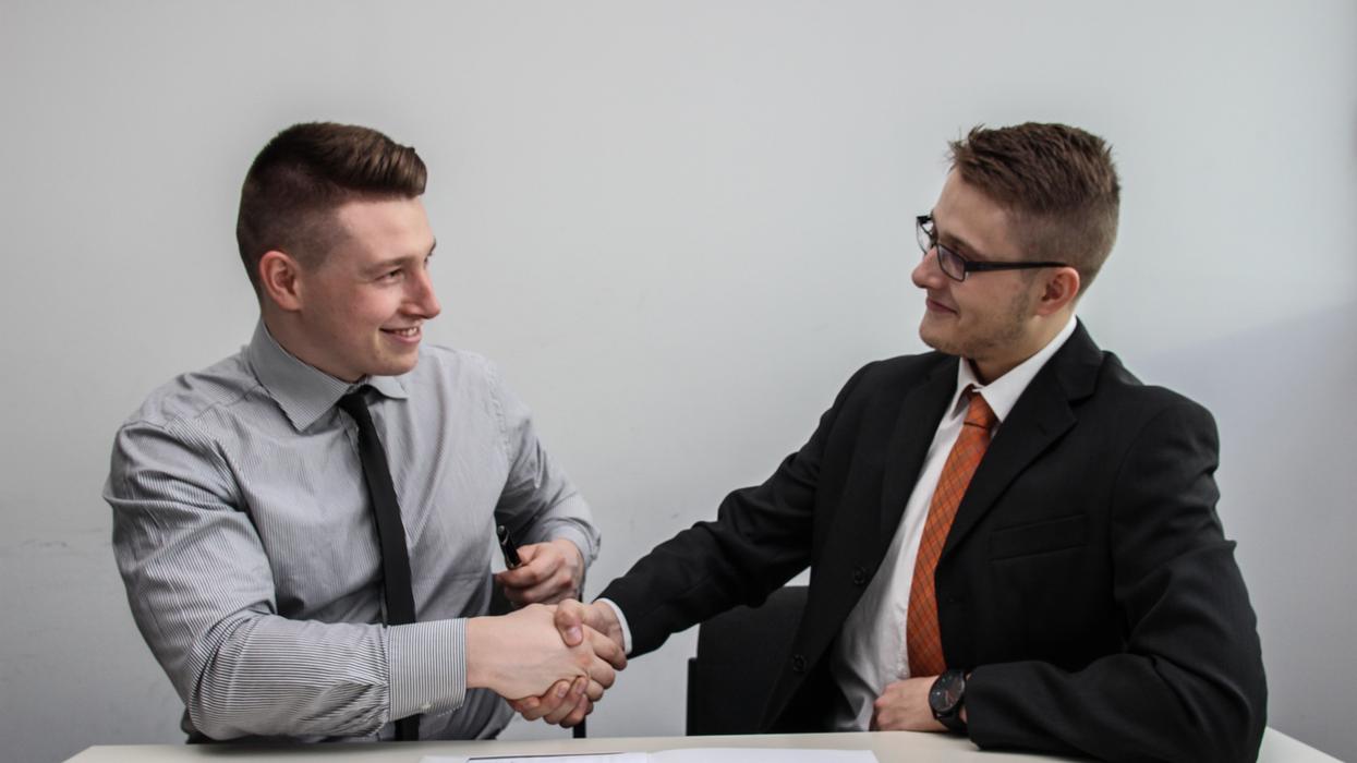 Two men shaking hands during job interview