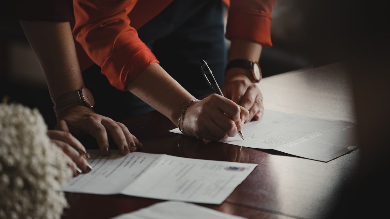 Two people look over paperwork on a desk