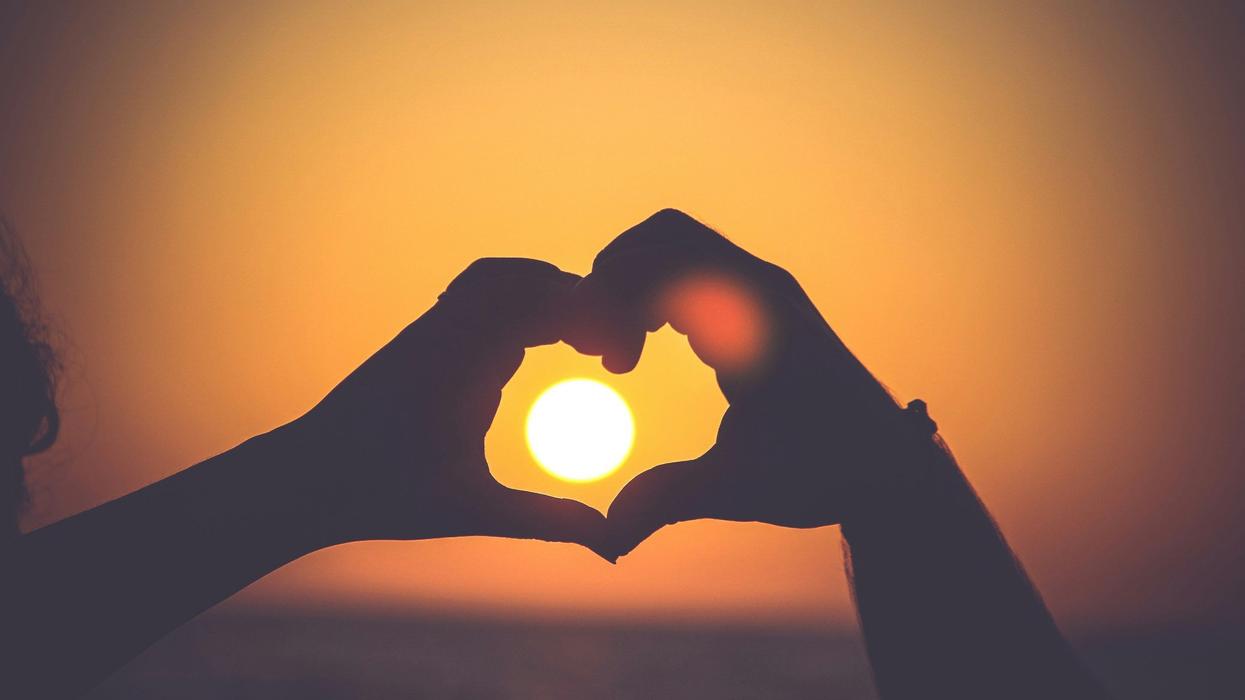 Two people putting their hands together to form a heart