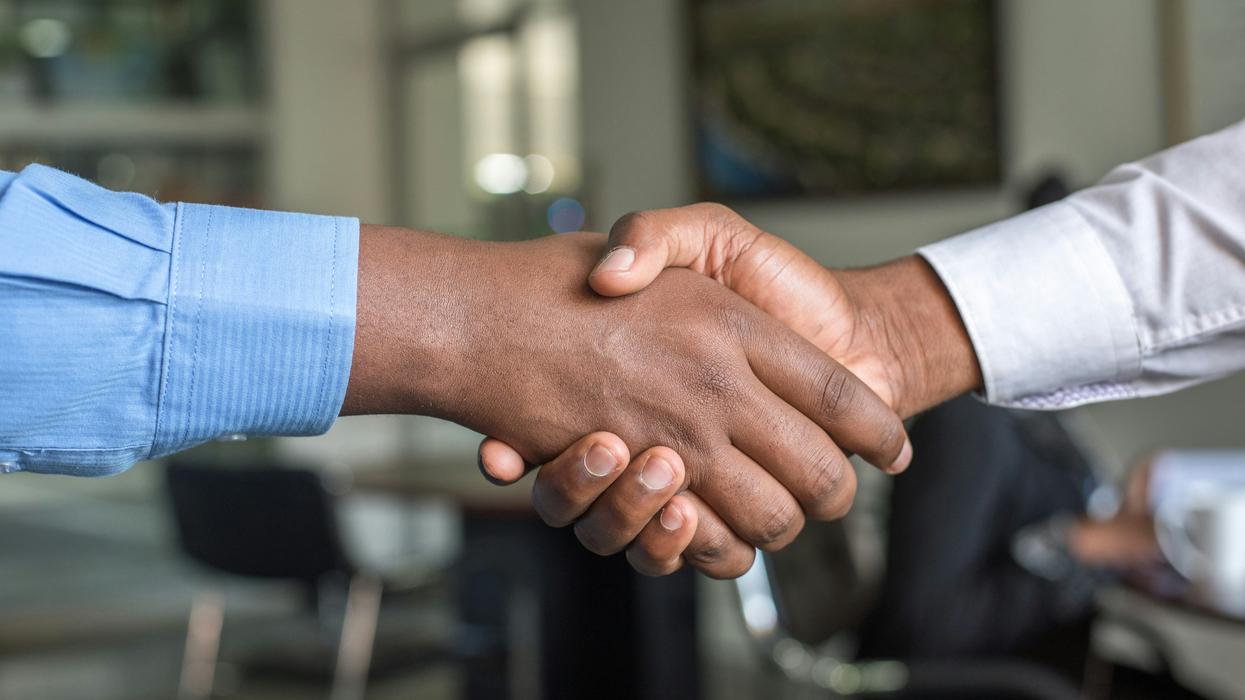 Two people shaking hands at work