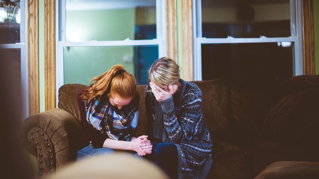Two people sitting on the sofa looking sad