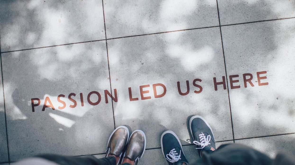 Two people standing on sidewalk with message that reads, "Passion led us here."
