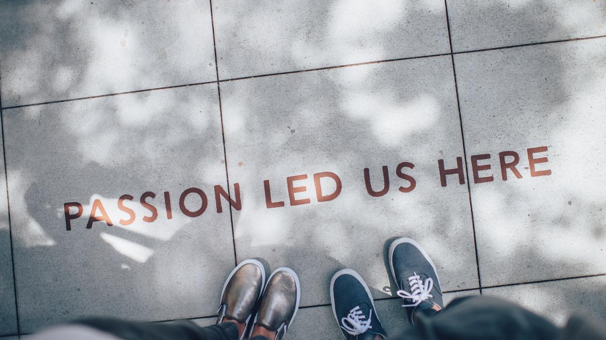 Two people standing on sidewalk with message that reads, "Passion led us here."