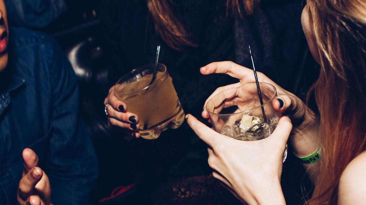 two people talking while holding drinks