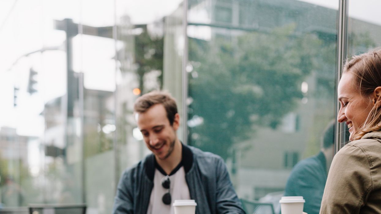 Two people talking with cups of coffee