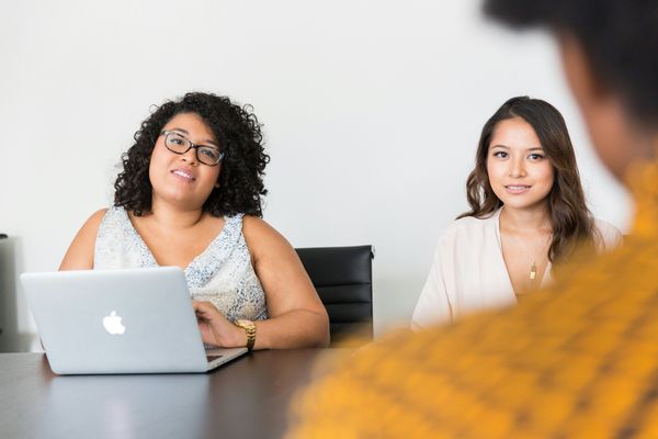 Two women interviewing someone for a job