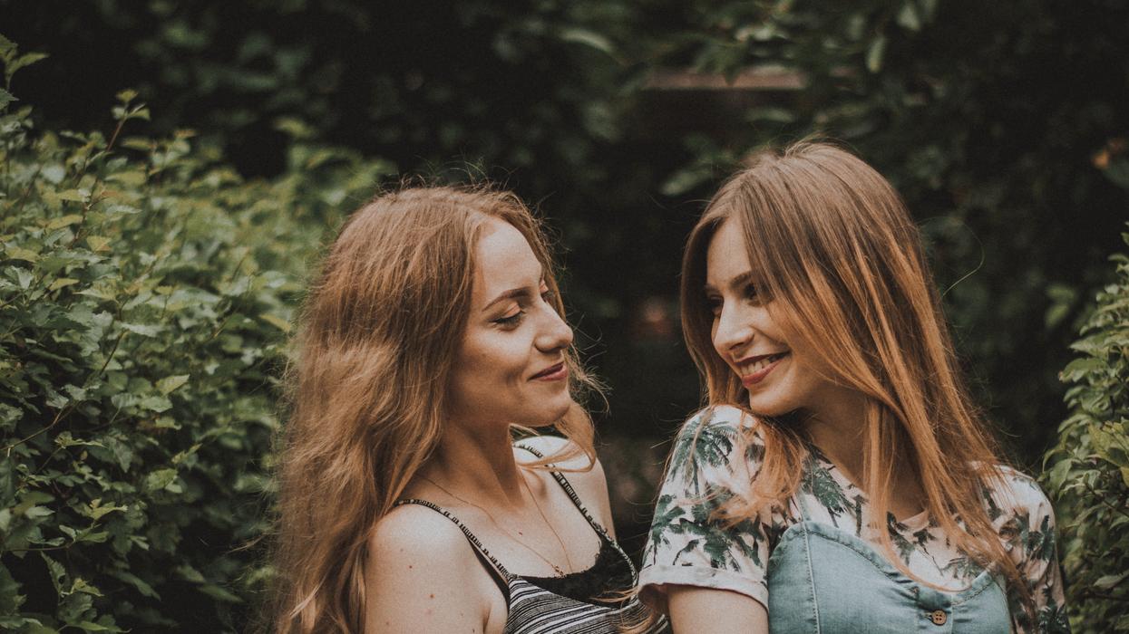 Two women smiling flirtatiously at each other