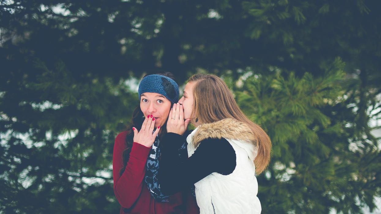Two women whispering in each other's ears