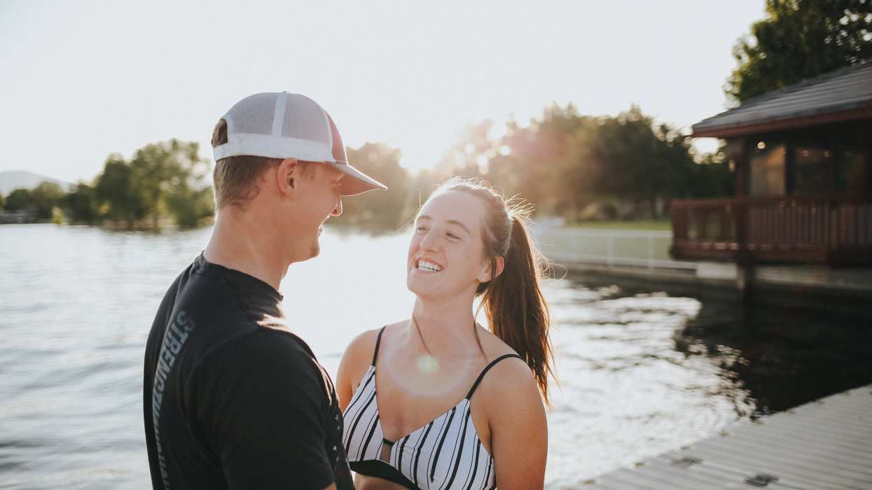 Two young people talking on a dock.