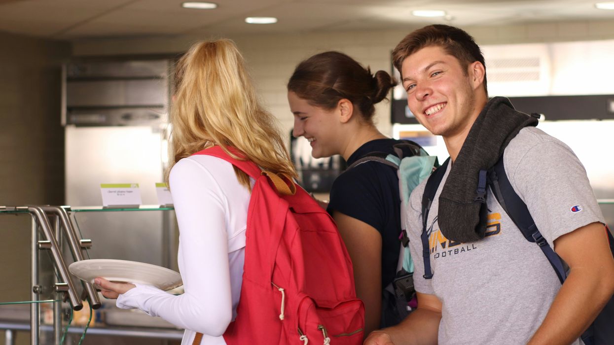 Two young women and one young man in line at a cafeteria