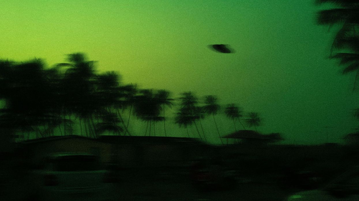 Unidentified flying object flying over a green sky