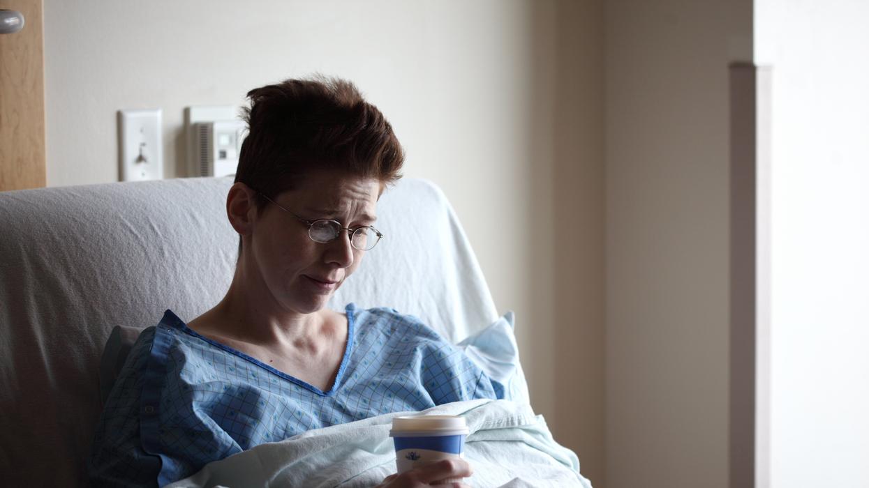Upset woman in hospital bed with coffee cup