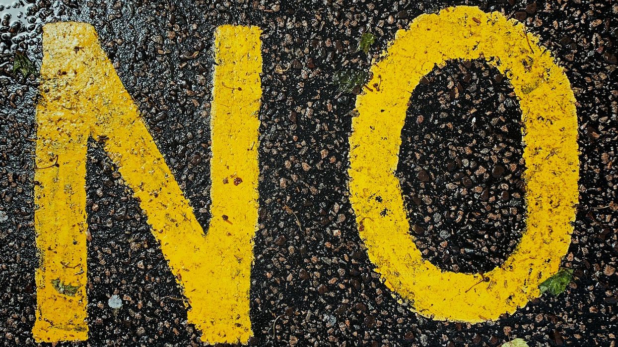 Wide shot of the word "NO" painted in yellow on the asphalt.