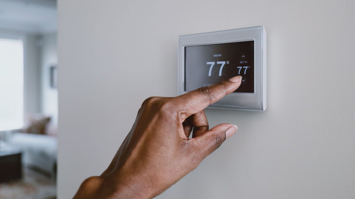 Woman adjusting thermostat