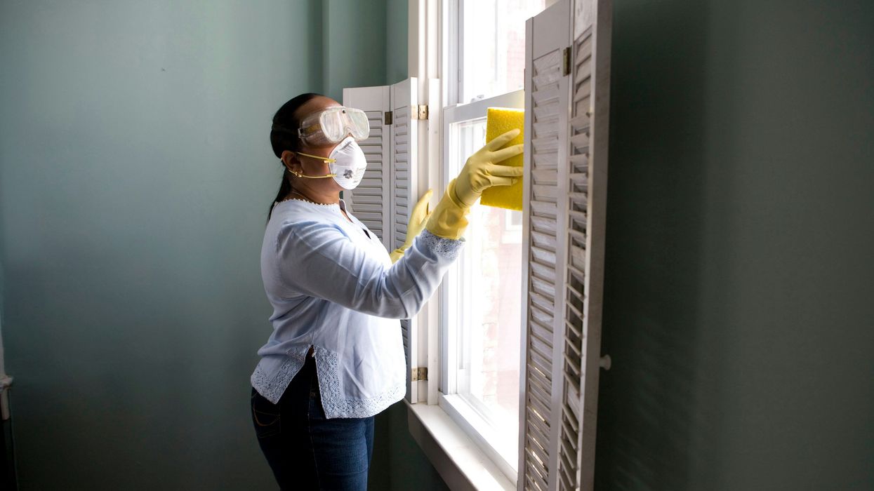 Woman cleaning the interior window of a home