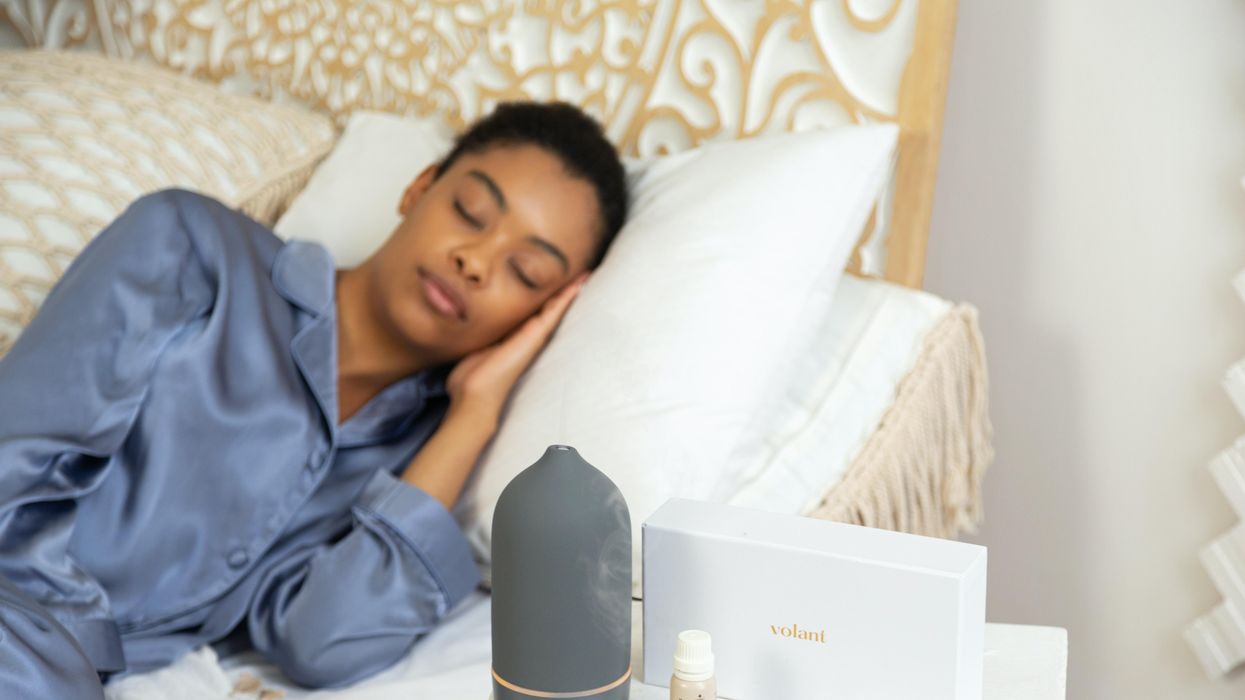 Woman comfortably sleeping with diffuser and essential oils