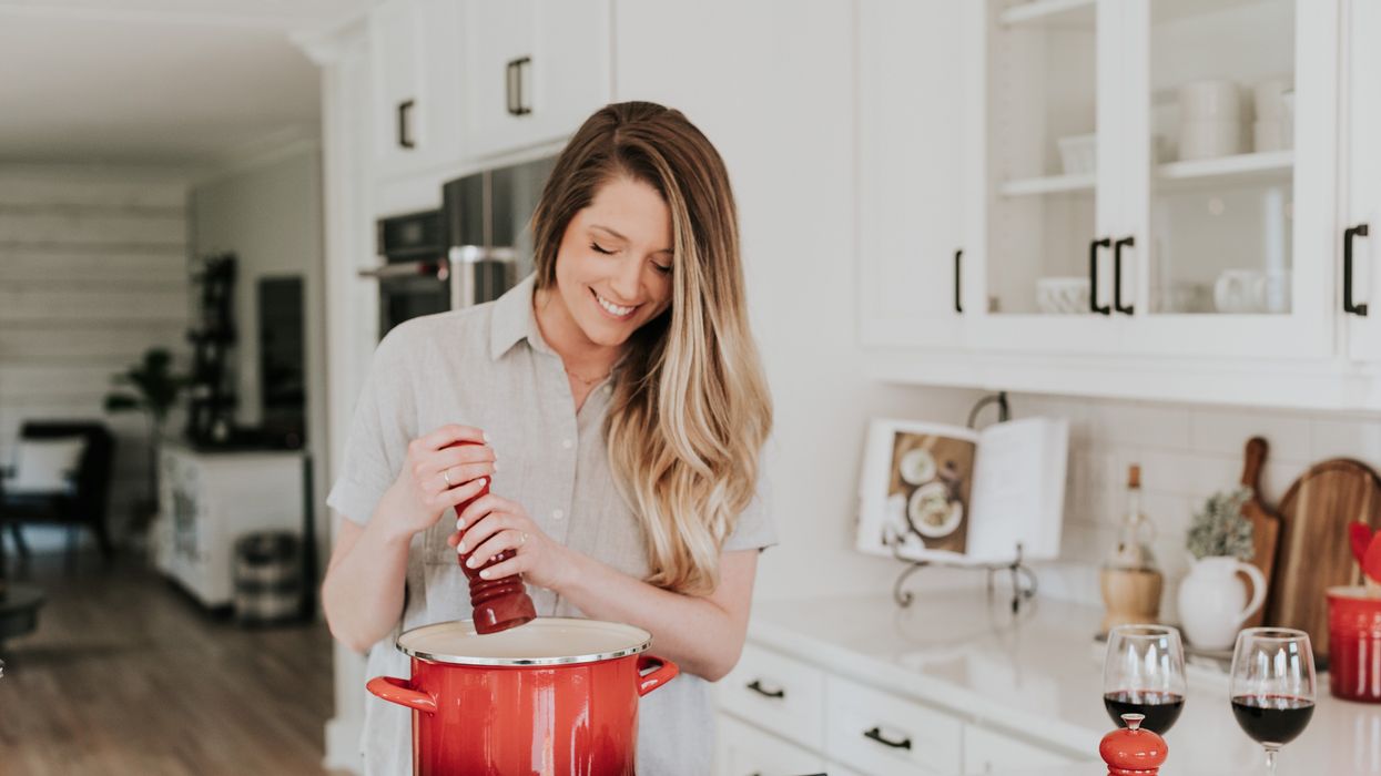 Woman cooking with large pot in kitchen