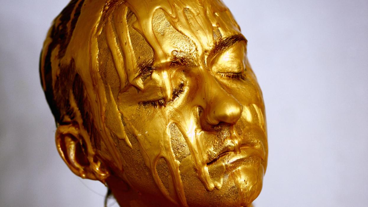 Woman covered in gold poster paint