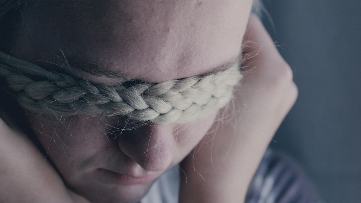 Woman covering eyes with braid