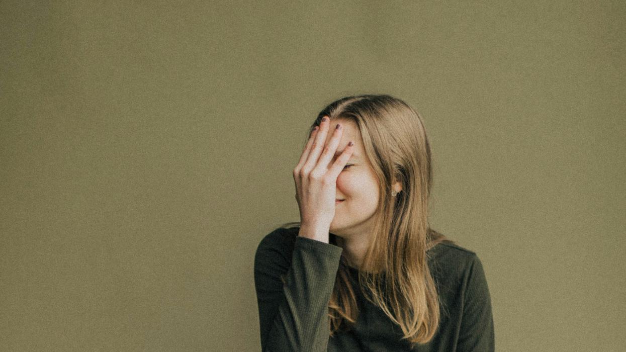 woman covering her face in embarrassment
