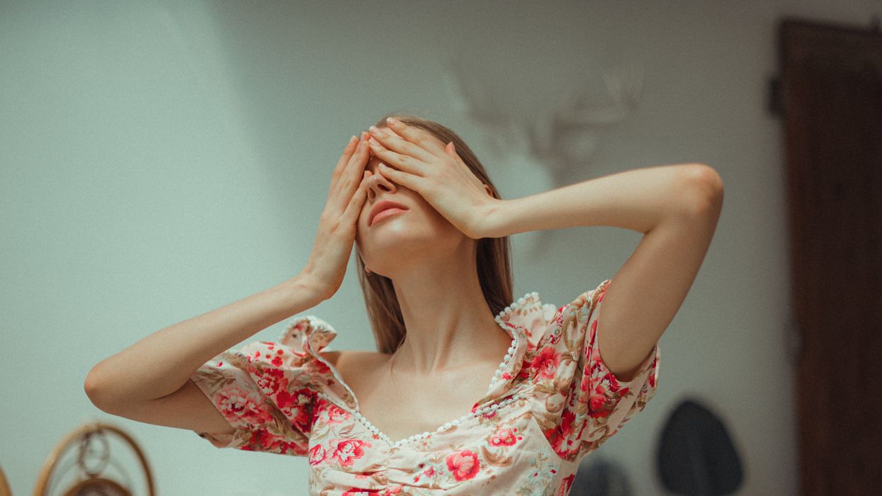 Woman covering her face with both hands