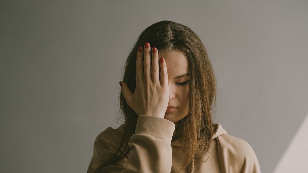 woman covering her face with her hand