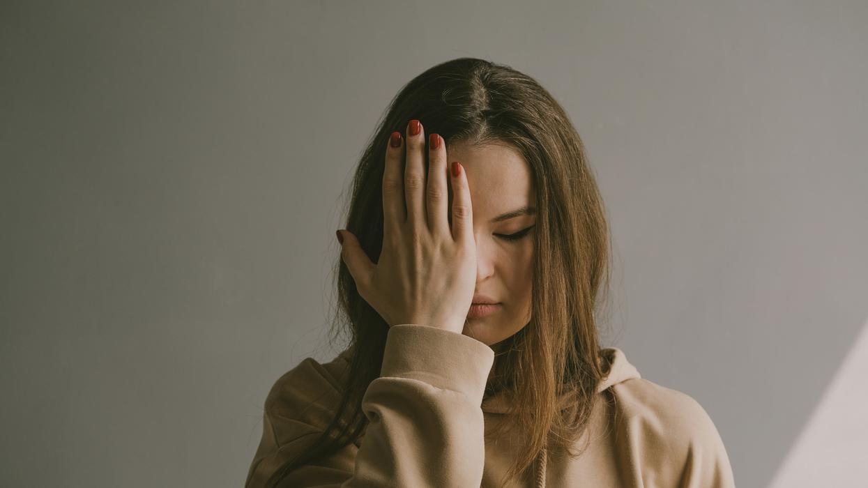 woman covering her face with her hand