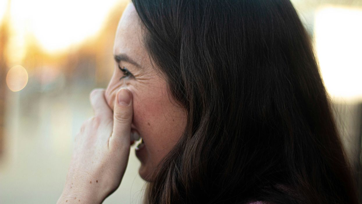 Woman covering her mouth laughing