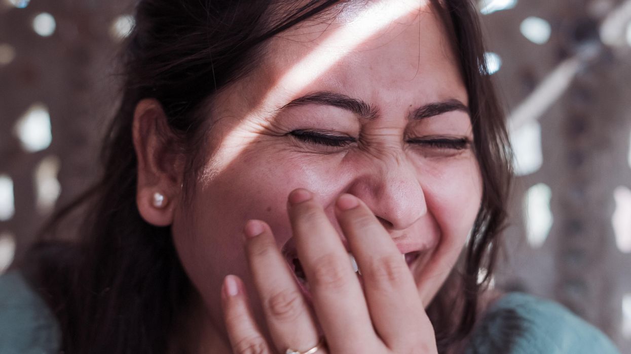 Woman covering her mouth to hide a laugh