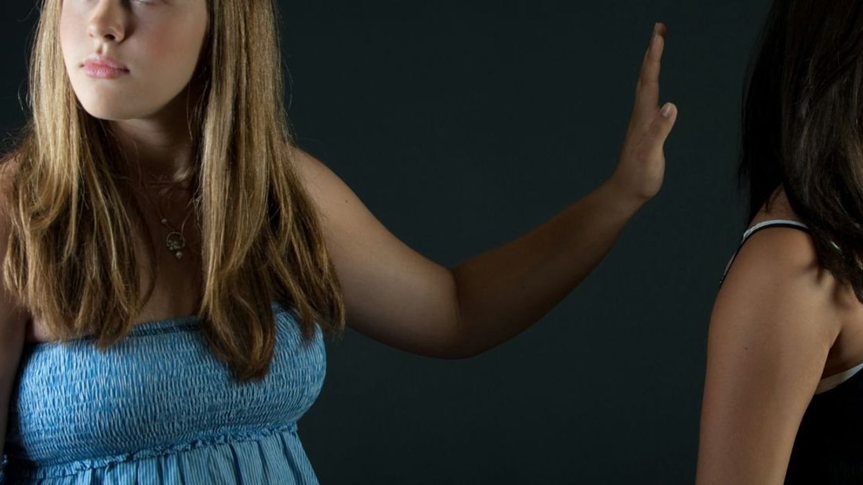 Woman dismissing female friend with hand gesture