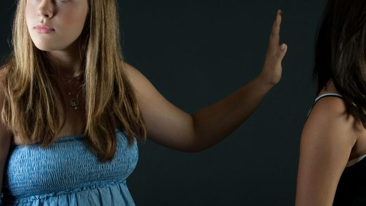 Woman dismissing female friend with hand gesture