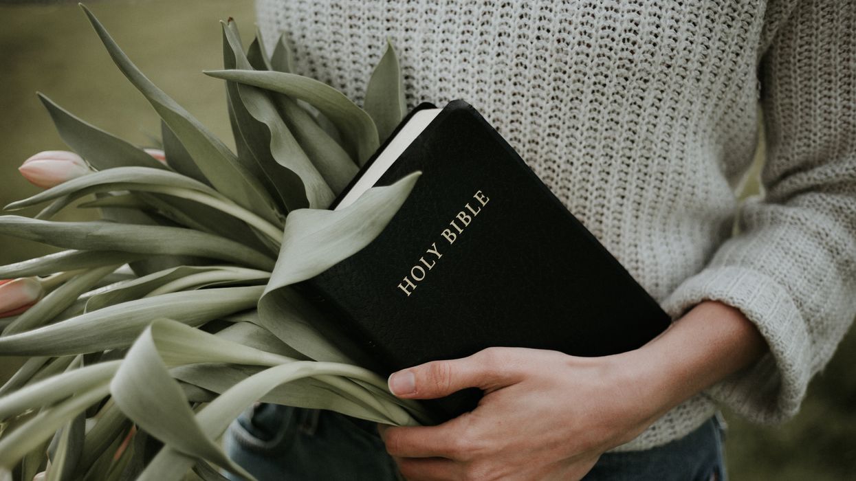 Woman holding a Bible and flowers