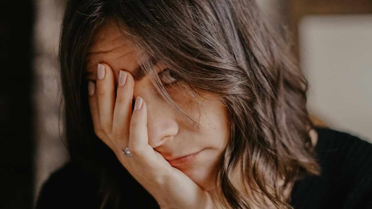 Woman holding head in her hands