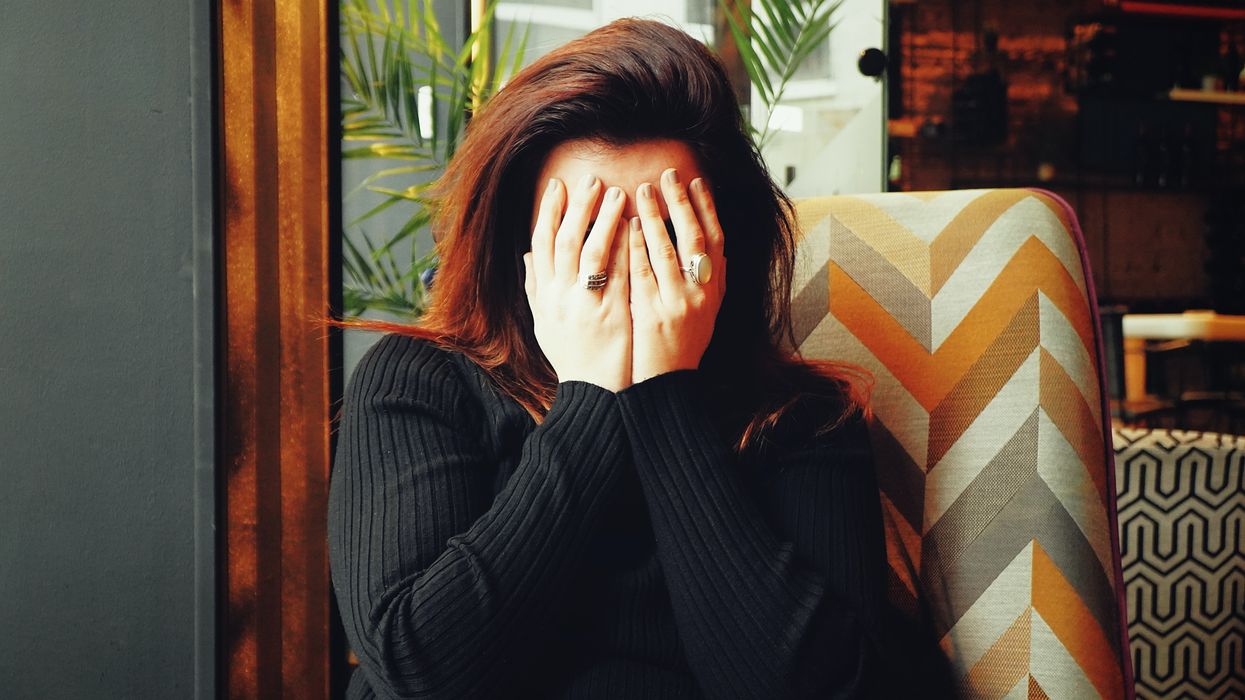 woman in black long sleeve shirt covering her face