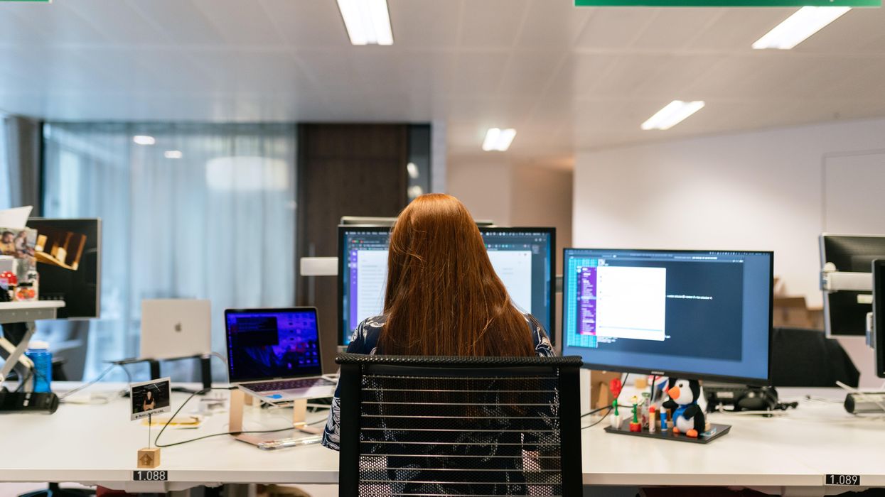 woman in black shirt sitting on chair in front of computer