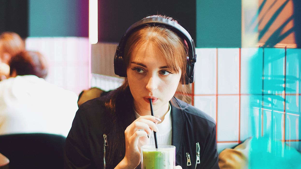 woman in cafe wearing noise canceling headphones