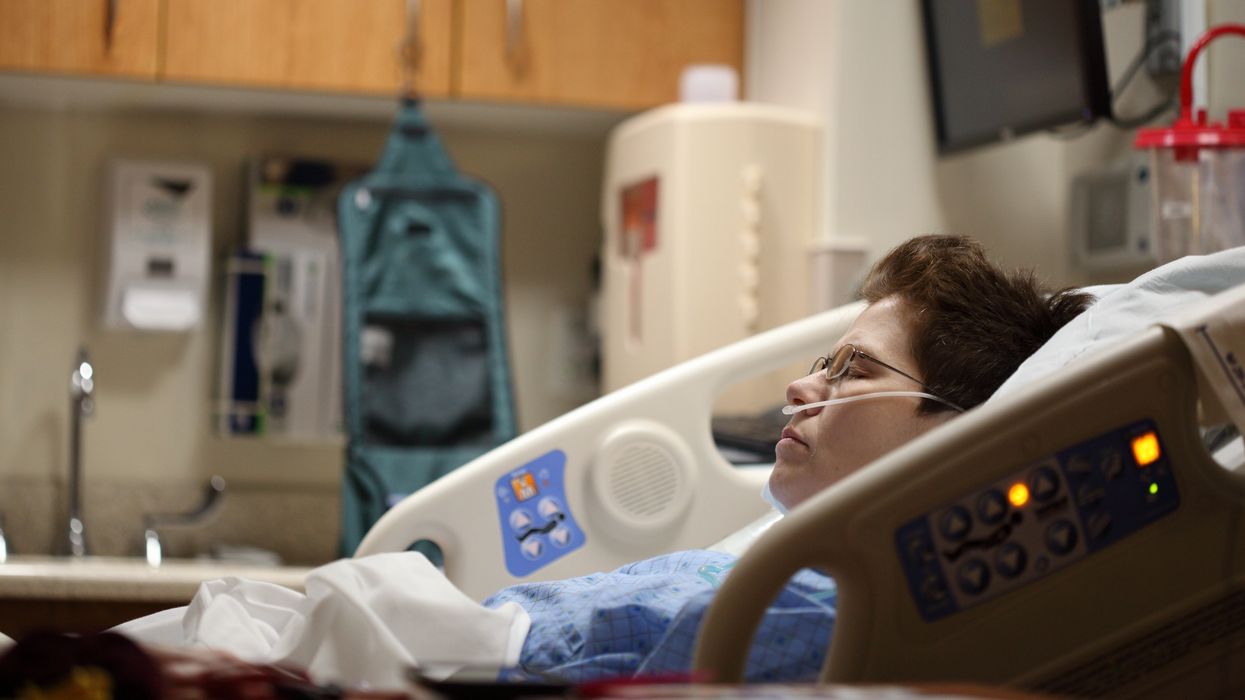 Woman in hospital bed after receiving anesthesia